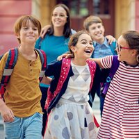 Lachende Kinden auf dem Schulweg